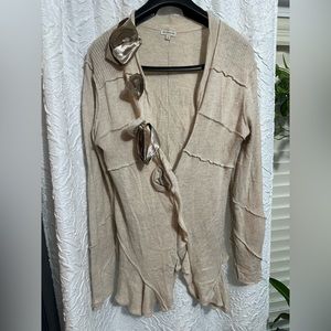Sweater tan with decorative flowers.